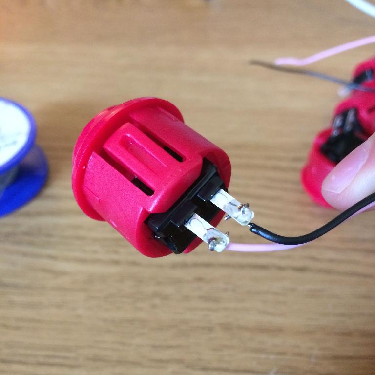 Wires soldered to the pins of an arcade push button